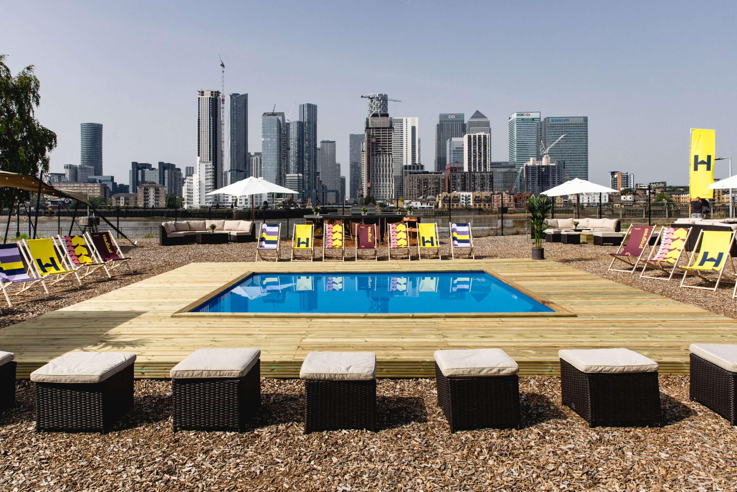 Magazine London summer party with a swimming pool installation overlooking the Canary Wharf skyline.